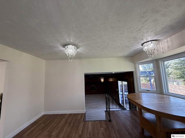 13910 Shirley St, Omaha, NE 68144 - unfurnished dining area featuring a chandelier, wood finished floors, and a textured ceiling