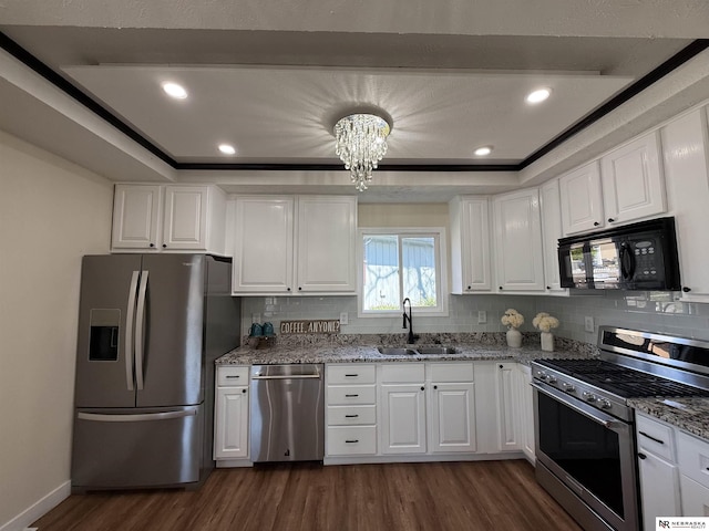 13910 Shirley St, Omaha, NE 68144 - kitchen featuring appliances with stainless steel finishes, dark wood-style flooring, a chandelier, white cabinetry, and recessed lighting