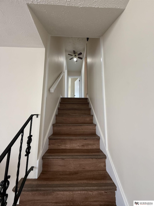 13910 Shirley St, Omaha, NE 68144 - staircase with a textured ceiling, a ceiling fan, and wood finished floors
