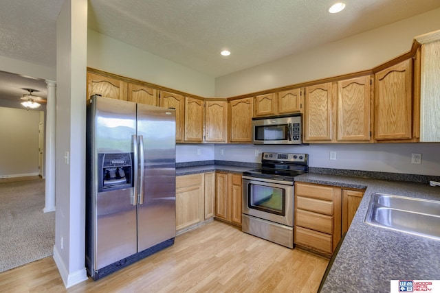 1215 Turtle Creek Rd, Lincoln, NE 68521 - kitchen featuring appliances with stainless steel finishes, light wood-style flooring, dark countertops, recessed lighting, and ornate columns