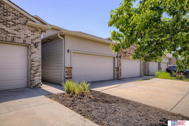 1215 Turtle Creek Rd, Lincoln, NE 68521 - view of front of property featuring driveway, an attached garage, brick siding, and stone siding