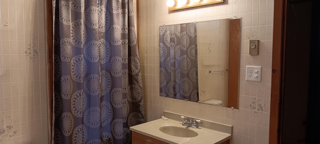 214 N Columbus Ave, Plymouth, NE 68424 - bathroom featuring tile walls, vanity, and a shower with curtain