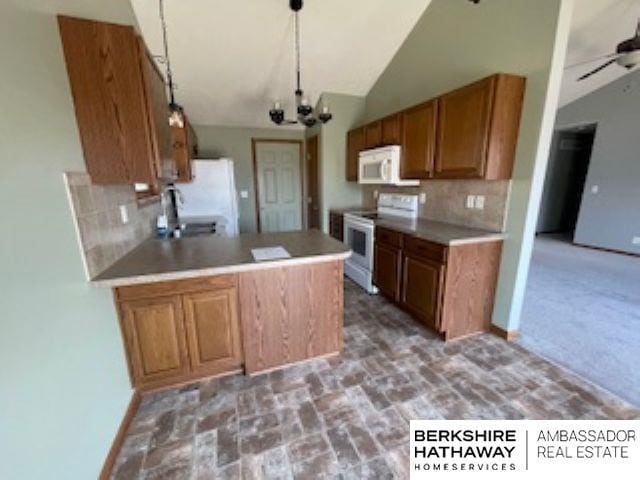 220 Orchard Pl, Hickman, NE 68372 - kitchen featuring white appliances, vaulted ceiling, brown cabinets, backsplash, and a peninsula