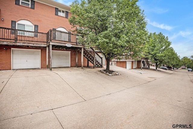 1913 Winnie Dr Unit 5, Bellevue, NE 68005 - view of front of house featuring brick siding, driveway, a garage, and stairway