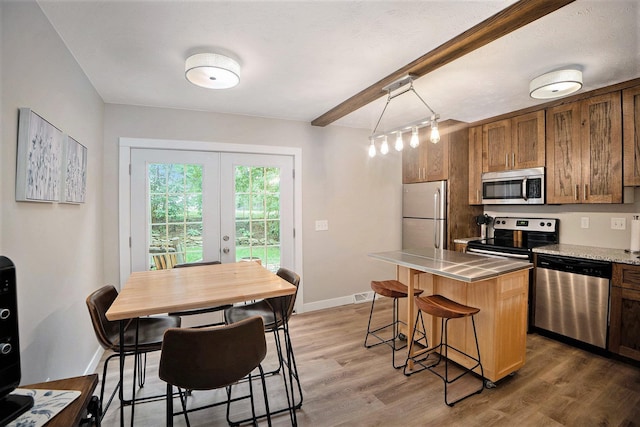 1913 Winnie Dr Unit 5, Bellevue, NE 68005 - kitchen with stainless steel appliances, a kitchen island, french doors, a breakfast bar, and wood finished floors