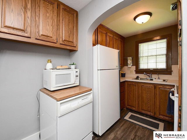 95 S Irving St, Fremont, NE 68025 - kitchen featuring white appliances, brown cabinetry, dark wood-style floors, light countertops, and arched walkways