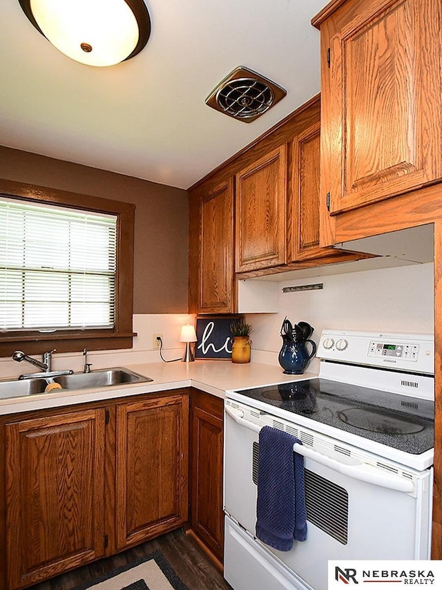 95 S Irving St, Fremont, NE 68025 - kitchen with white electric range, brown cabinets, light countertops, and dark wood-style floors