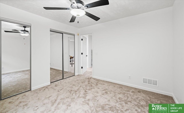 13512 S 55th St, Papillion, NE 68133 - unfurnished bedroom with two closets, carpet floors, a textured ceiling, and ceiling fan