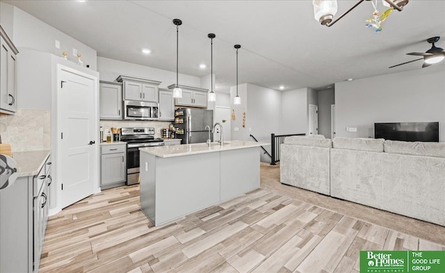 13512 S 55th St, Papillion, NE 68133 - kitchen featuring stainless steel appliances, gray cabinetry, open floor plan, light wood-style floors, and recessed lighting