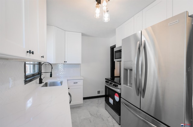 3018 S 42nd St, Lincoln, NE 68506 - kitchen featuring stainless steel appliances, light marble finish flooring, light stone counters, decorative backsplash, and white cabinetry