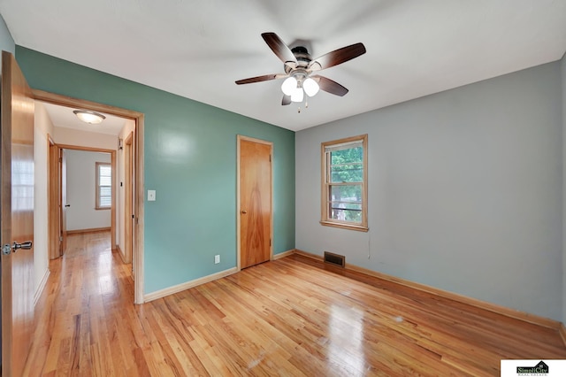 2340 S 36th St, Lincoln, NE 68506 - unfurnished bedroom with multiple windows, light wood finished floors, a closet, and a ceiling fan