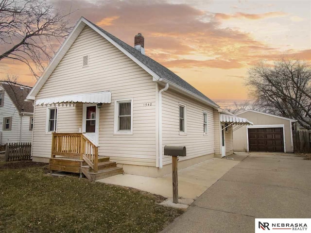 1548 E 5th St, Fremont, NE 68025 - view of front of property featuring a chimney, driveway, a garage, an outbuilding, and roof with shingles
