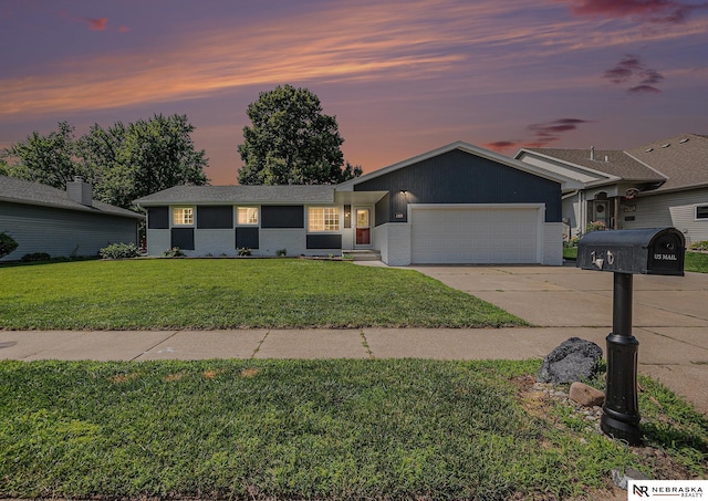 1409 Nelson Ln, Fremont, NE 68025 - single story home featuring an attached garage, concrete driveway, a lawn, and brick siding