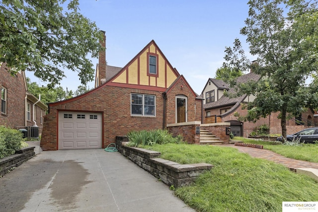 6024 Poppleton Ave, Omaha, NE 68106 - tudor house with a chimney, driveway, a garage, stucco siding, and brick siding