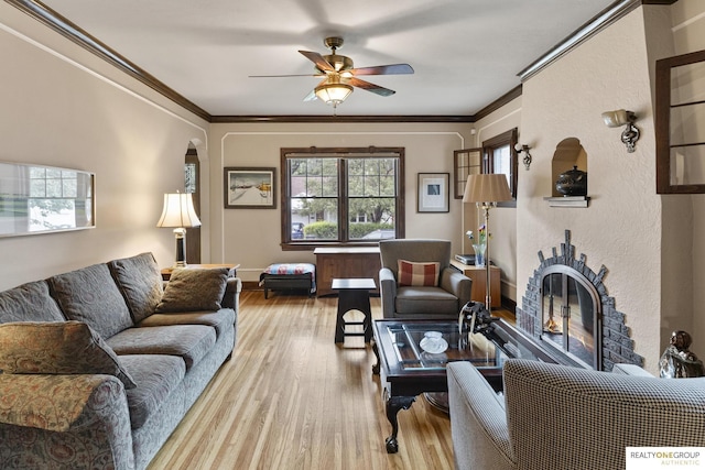 6024 Poppleton Ave, Omaha, NE 68106 - living area with wood finished floors, a ceiling fan, a glass covered fireplace, ornamental molding, and arched walkways