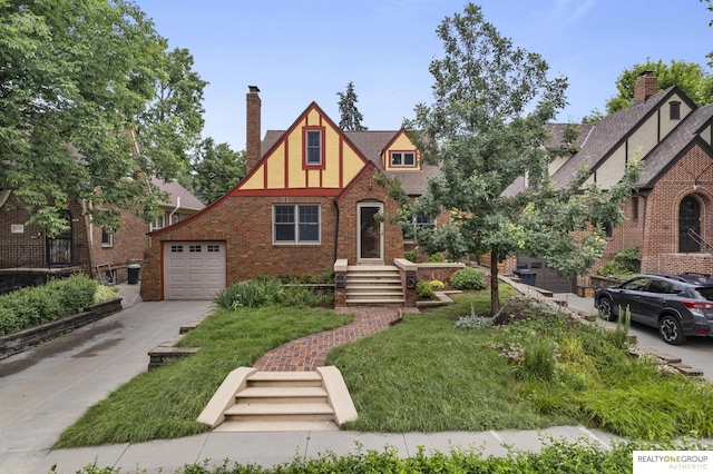 6024 Poppleton Ave, Omaha, NE 68106 - tudor house with a chimney, driveway, brick siding, a front lawn, and a garage