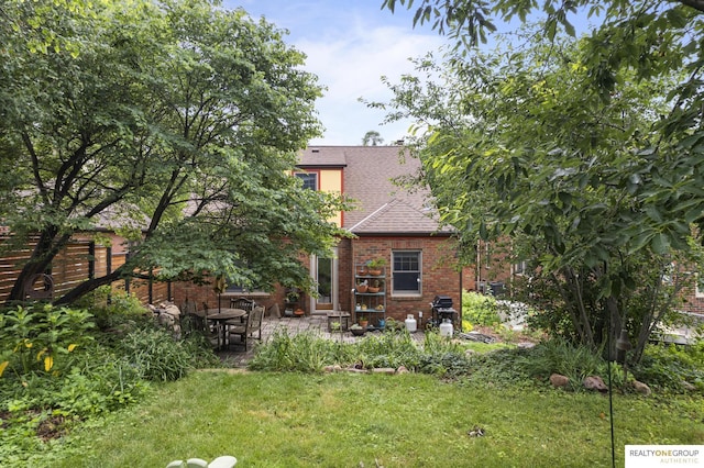 6024 Poppleton Ave, Omaha, NE 68106 - back of property with brick siding, roof with shingles, and a patio area