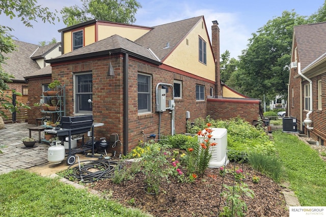 6024 Poppleton Ave, Omaha, NE 68106 - view of side of home with a chimney, brick siding, and stucco siding