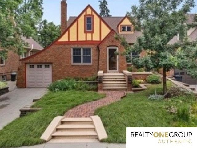 6024 Poppleton Ave, Omaha, NE 68106 - tudor home featuring concrete driveway and a chimney