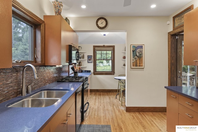 6024 Poppleton Ave, Omaha, NE 68106 - kitchen with dark countertops, black microwave, light wood-style floors, decorative backsplash, and gas stove