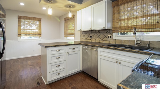 4211 S 36th St, Lincoln, NE 68506 - kitchen with stainless steel dishwasher, a peninsula, dark wood finished floors, dark countertops, and a wainscoted wall