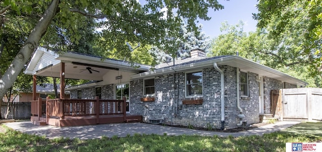4211 S 36th St, Lincoln, NE 68506 - back of house featuring ceiling fan, a wooden deck, a chimney, a patio area, and brick siding