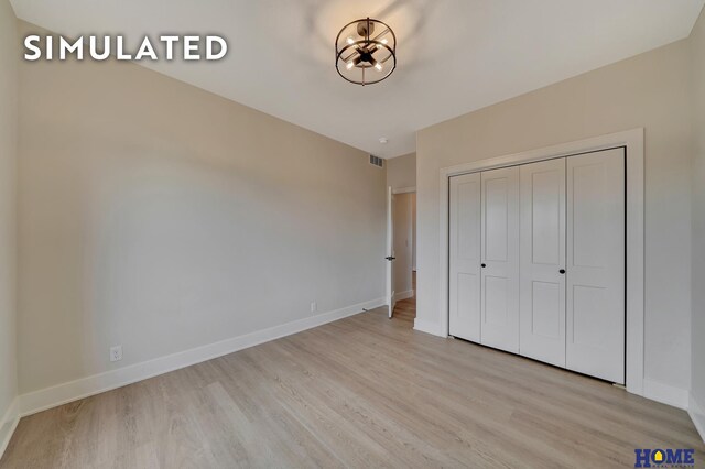 640 Eloise Ave, Lincoln, NE 68520 - unfurnished bedroom with light wood-type flooring, a closet, and a chandelier