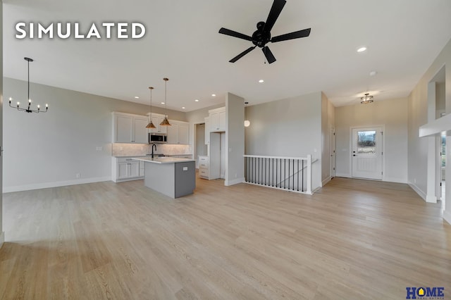 640 Eloise Ave, Lincoln, NE 68520 - unfurnished living room with a chandelier, light wood-style flooring, ceiling fan, and recessed lighting
