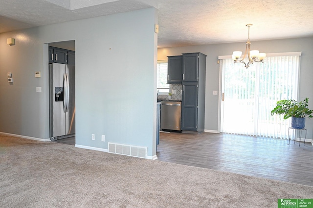 2412 Lewis And Clark Rd, Bellevue, NE 68123 - unfurnished living room with carpet flooring, a chandelier, plenty of natural light, and a textured ceiling
