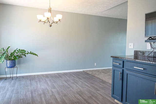 2412 Lewis And Clark Rd, Bellevue, NE 68123 - kitchen with a chandelier, wood finished floors, pendant lighting, and blue cabinetry
