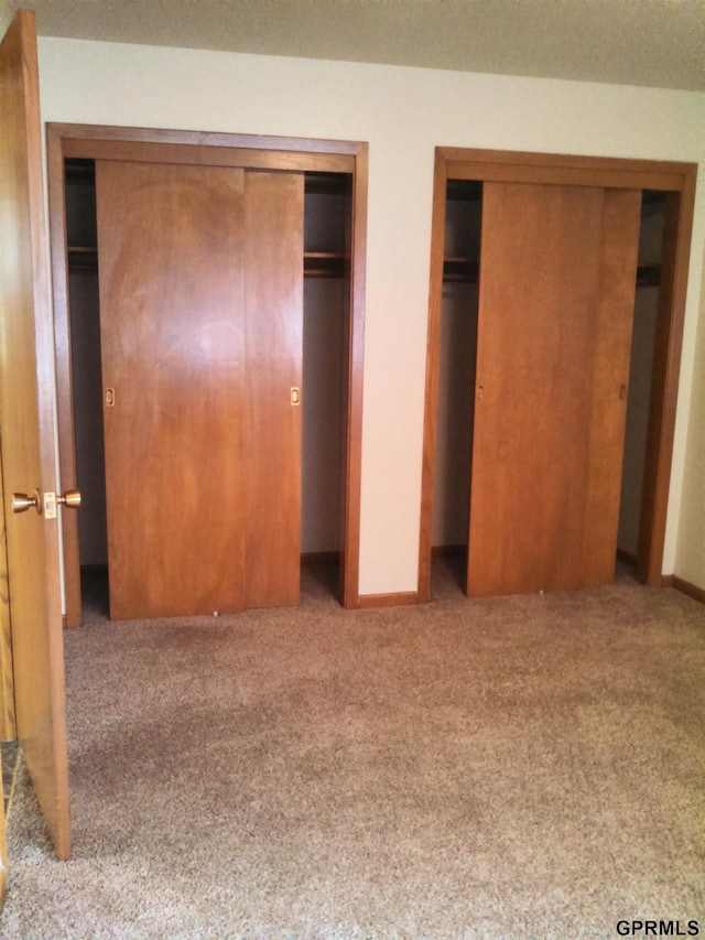1321 D St, Lincoln, NE 68502 - unfurnished bedroom with two closets and carpet floors