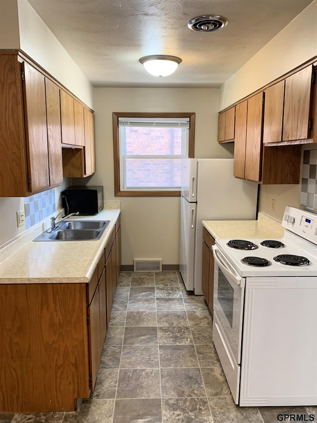 1321 D St, Lincoln, NE 68502 - kitchen with white range with electric cooktop, light countertops, brown cabinetry, and dark stone finish floors