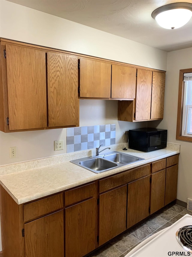 1321 D St, Lincoln, NE 68502 - kitchen with black microwave, light countertops, and brown cabinetry