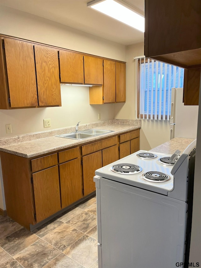 1321 D St, Lincoln, NE 68502 - kitchen featuring white appliances, light countertops, brown cabinetry, and light stone finish floors