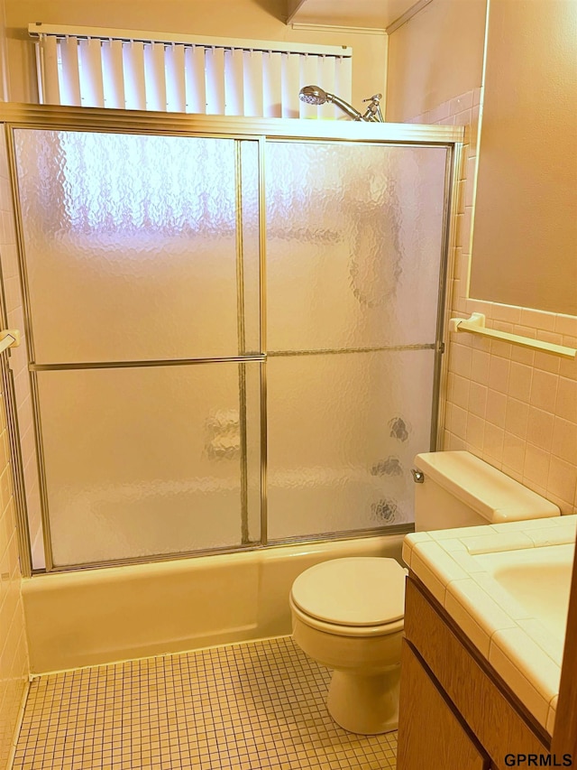 1321 D St, Lincoln, NE 68502 - bathroom featuring vanity, enclosed tub / shower combo, tile walls, and tile patterned floors