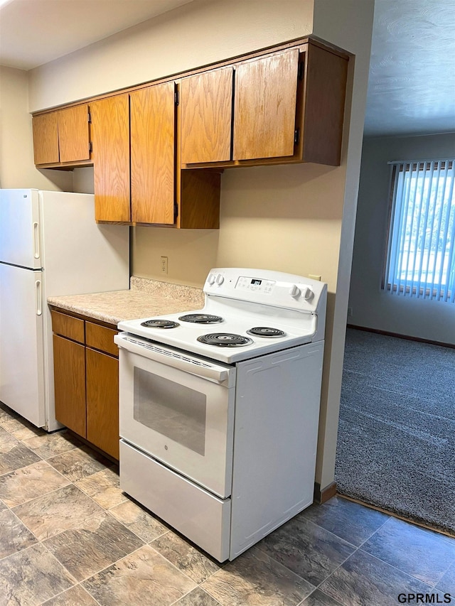 1321 D St, Lincoln, NE 68502 - kitchen with white appliances, light countertops, stone finish flooring, and brown cabinets
