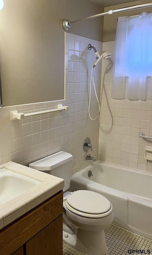 1321 D St, Lincoln, NE 68502 - full bathroom featuring vanity, tub / shower combination, tile walls, tile patterned floors, and wainscoting