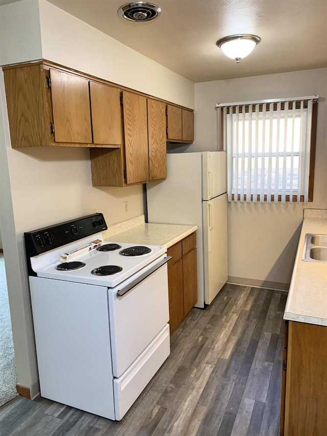 1321 D St, Lincoln, NE 68502 - kitchen with white range with electric cooktop, dark wood-style floors, light countertops, and brown cabinets