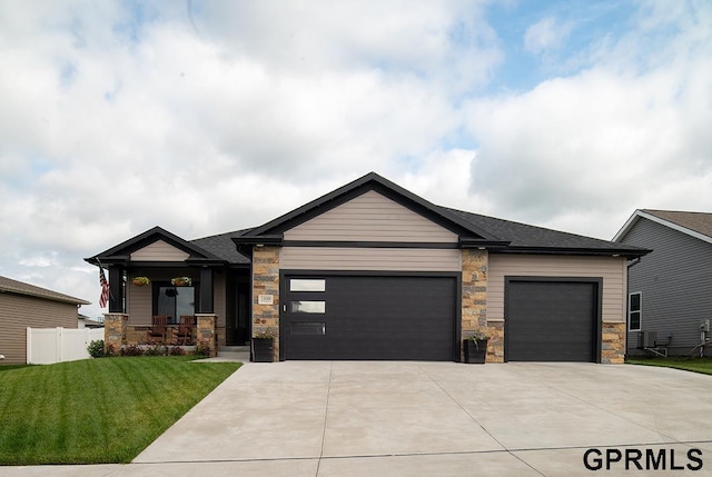 1600 W Avalanche Rd, Lincoln, NE 68521 - view of front of home with a garage, concrete driveway, stone siding, and a porch