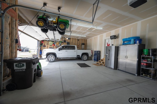 1600 W Avalanche Rd, Lincoln, NE 68521 - garage with stainless steel fridge and a garage door opener