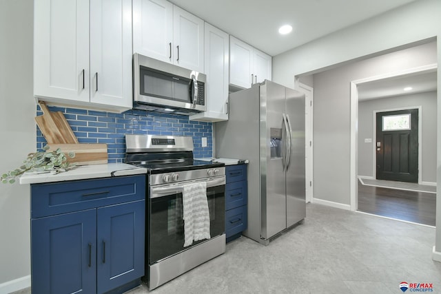 1210 S 44th St, Lincoln, NE 68510 - kitchen featuring appliances with stainless steel finishes, white cabinetry, tasteful backsplash, light countertops, and blue cabinets