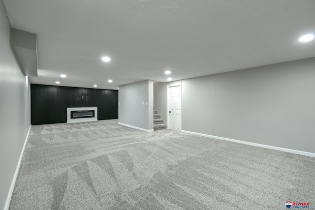 1210 S 44th St, Lincoln, NE 68510 - finished basement with recessed lighting, light colored carpet, stairway, and a glass covered fireplace