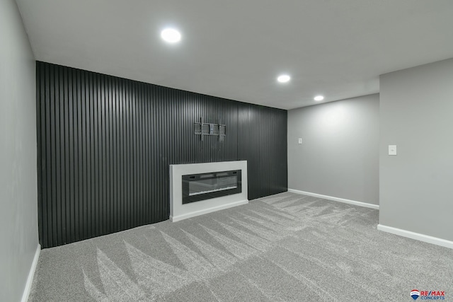 1210 S 44th St, Lincoln, NE 68510 - unfurnished living room featuring recessed lighting, a glass covered fireplace, and carpet floors