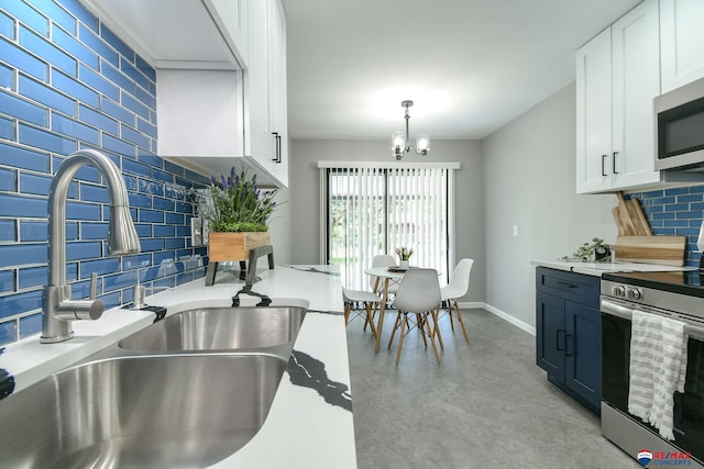 1210 S 44th St, Lincoln, NE 68510 - kitchen featuring stainless steel appliances, tasteful backsplash, finished concrete flooring, white cabinetry, and a chandelier