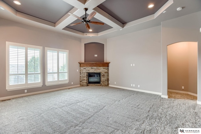 8023 S 193rd St, Gretna, NE 68028 - unfurnished living room featuring a ceiling fan, coffered ceiling, arched walkways, carpet floors, and a stone fireplace