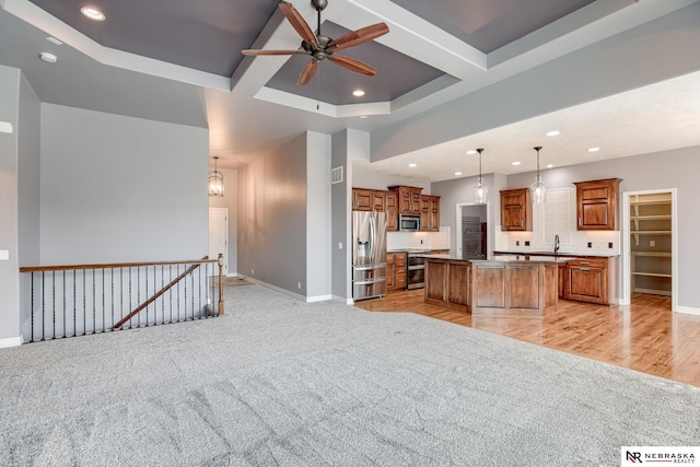 8023 S 193rd St, Gretna, NE 68028 - kitchen featuring appliances with stainless steel finishes, open floor plan, brown cabinets, light carpet, and ceiling fan