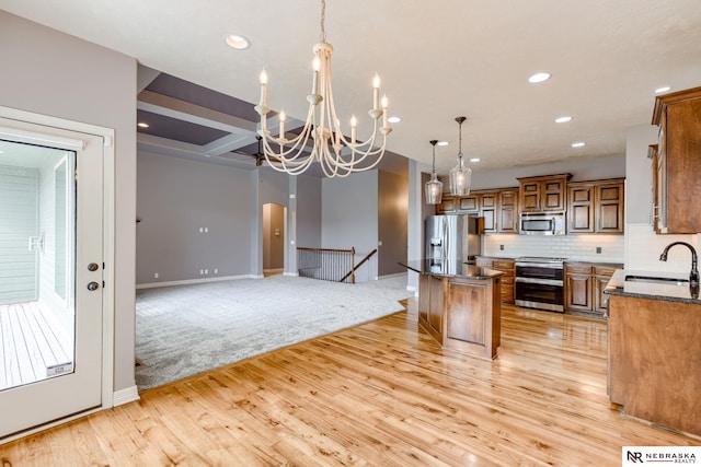 8023 S 193rd St, Gretna, NE 68028 - kitchen featuring appliances with stainless steel finishes, brown cabinetry, a kitchen island, light wood-style flooring, and arched walkways