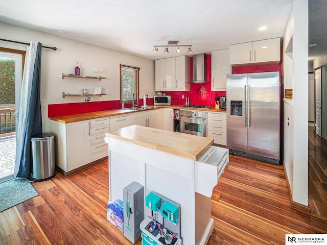 7533 Sherman St, Lincoln, NE 68506 - kitchen with stainless steel appliances, wall chimney range hood, butcher block counters, and light wood-style floors