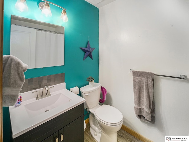 7533 Sherman St, Lincoln, NE 68506 - bathroom featuring vanity, backsplash, and wood finished floors
