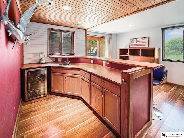 7533 Sherman St, Lincoln, NE 68506 - kitchen with wine cooler, wood ceiling, light wood-style floors, and a peninsula